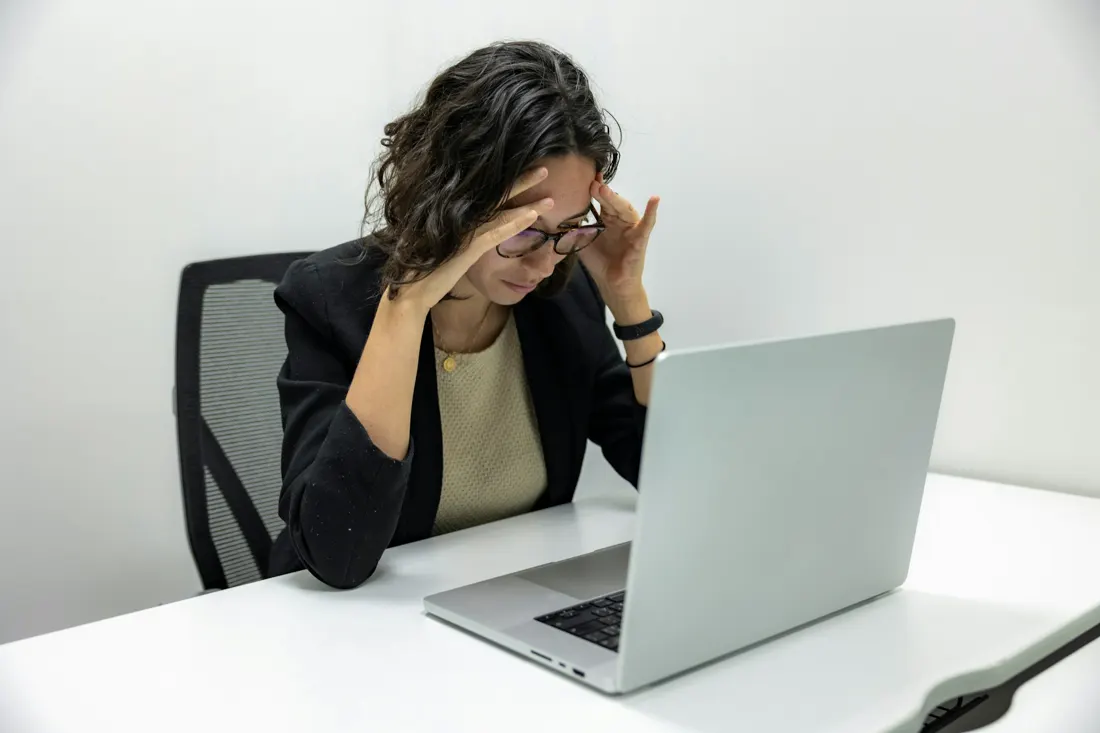 Mulher diante do notebook, com dificuldade de concentração